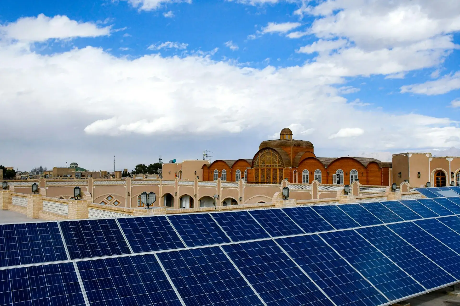 Photovoltaic solar panels on a hotel rooftop against a blue sky